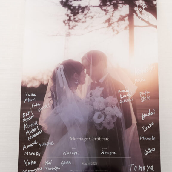 寄り添う新郎新婦の写真に、ゲストのサインが書き込まれたアクリルの結婚証明書