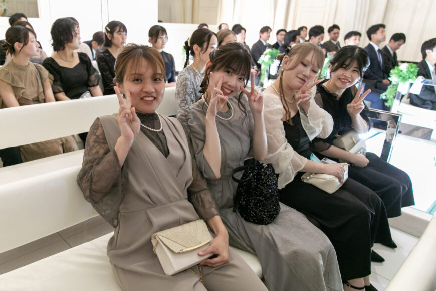 チャペルの席で笑顔を見せる新婦のご友人