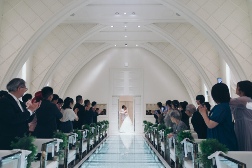 挙式を終え、チャペルの扉の向こうに立つ新郎新婦