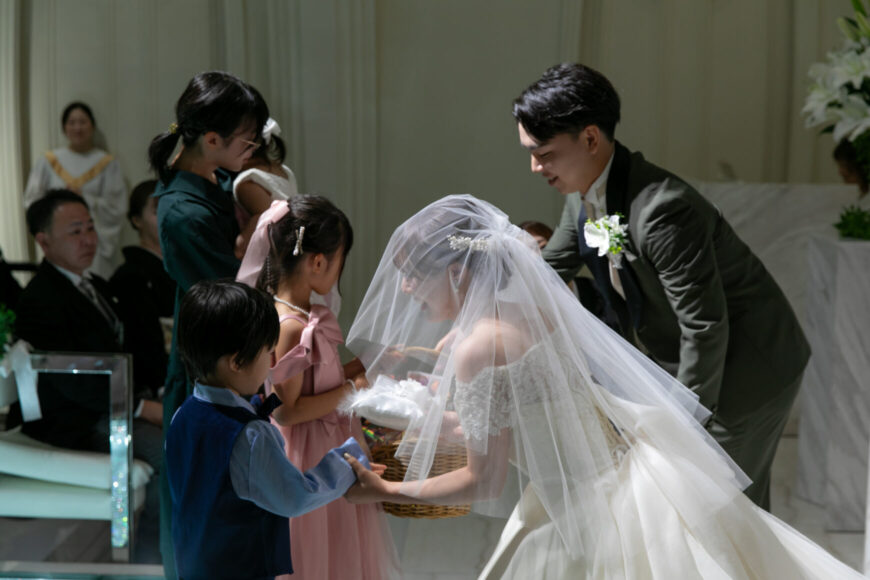 お子さまたちから指輪を受け取る新郎新婦