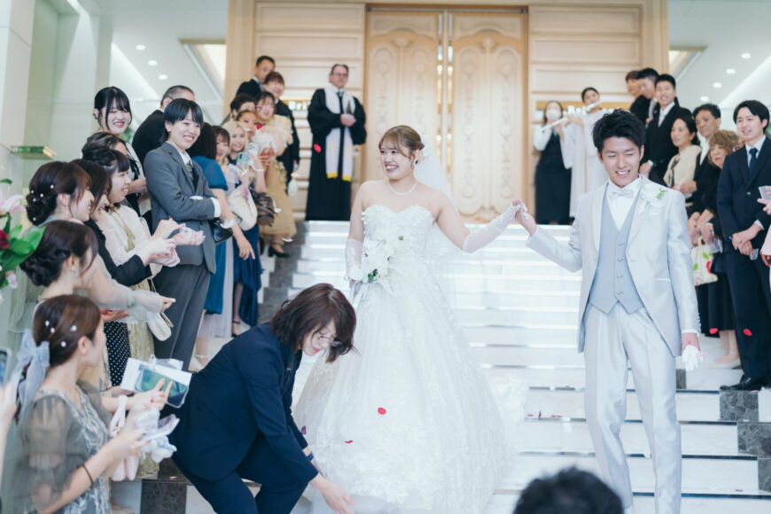 大階段でフラワーシャワーの祝福を受ける新郎新婦