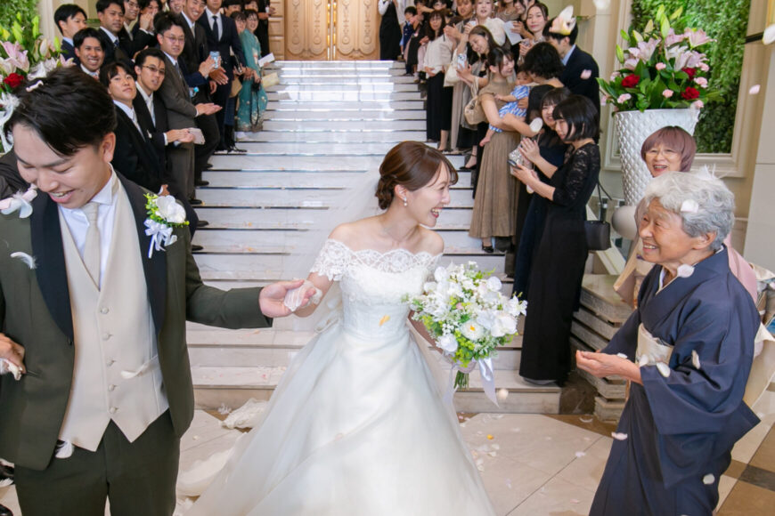 大階段でおばあさまと笑顔を交わす新婦