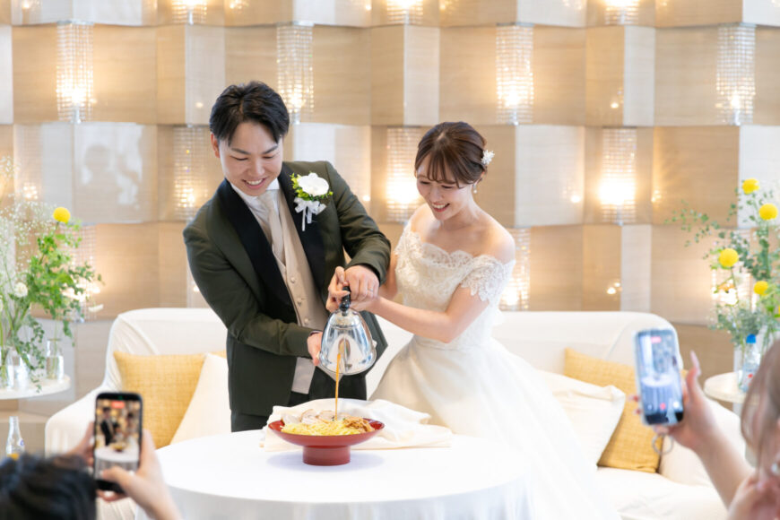 ラーメンにスープを注ぐ新郎新婦の共同作業