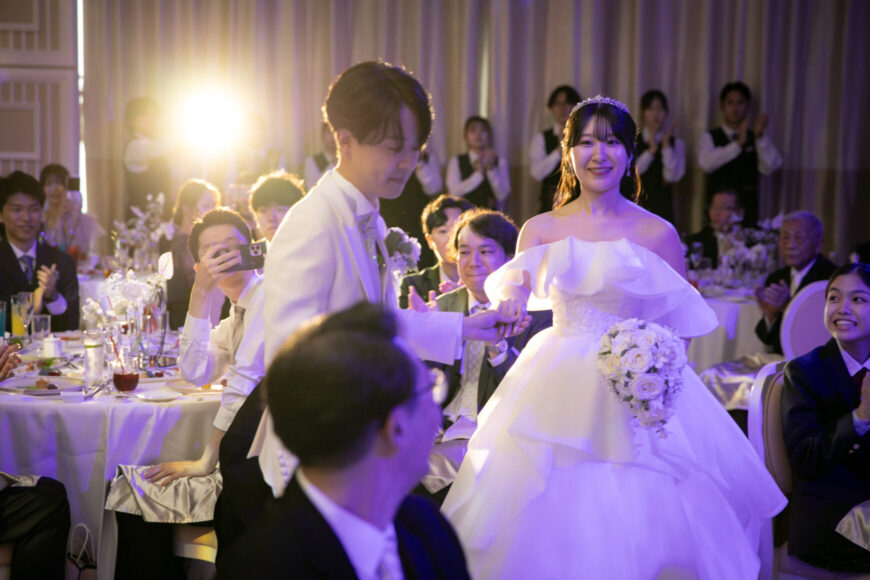 ゲストに祝福されながら披露宴会場へ入場する新郎新婦