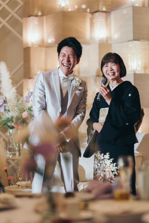 お母さまと笑顔で中座する新郎