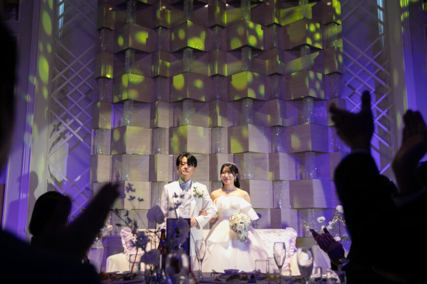 ライトアップされた高砂の新郎新婦と盛り上がるゲスト