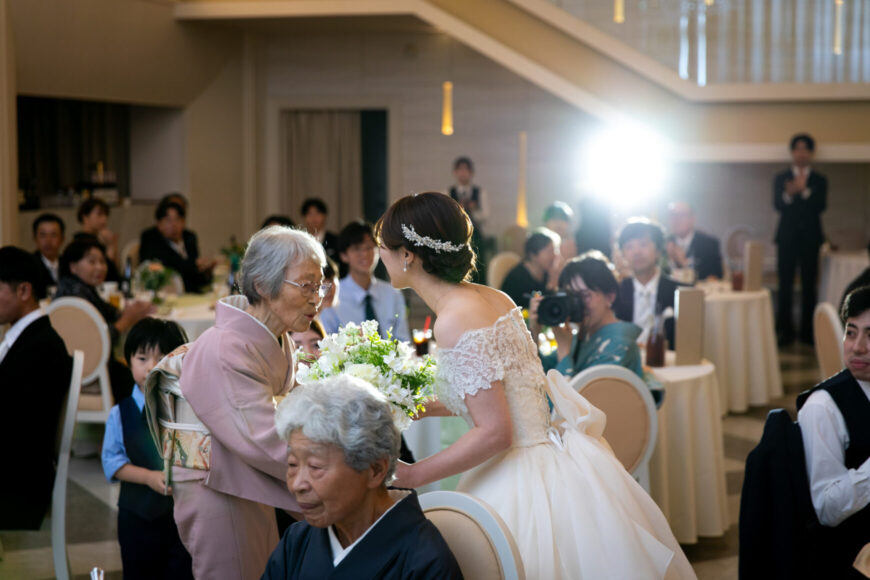 テーブルでおばあさまと言葉を交わす新婦