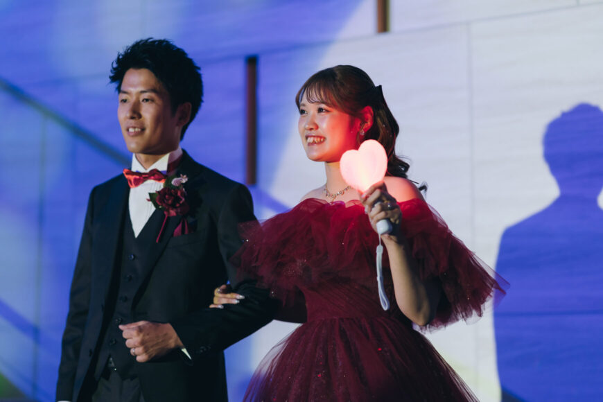 赤いカラードレスとブラックタキシードで再入場する新郎新婦