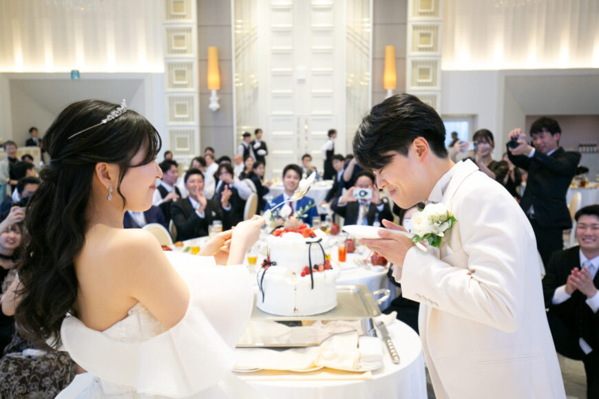 ファーストバイトでケーキを食べさせ合う新郎新婦