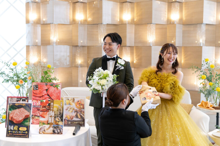 ゲームの景品を紹介する新郎新婦