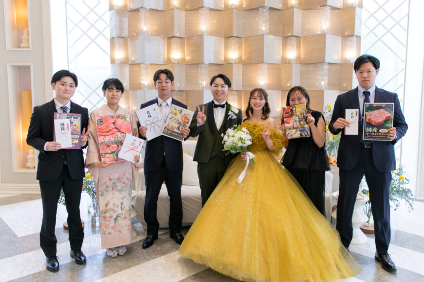 景品を手にしたゲストと新郎新婦の記念写真