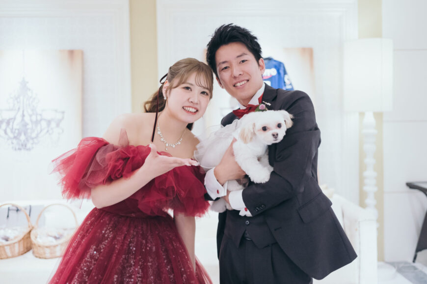 愛犬を抱いて笑顔を見せる新郎新婦